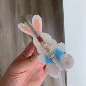 Detail of cute rabbit hair claw clip made of iridescent acetate with gold metal spring
