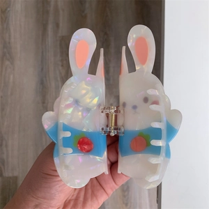 Detail showing the iridescent acetate rabbit hair claw clip with strawberry patterns