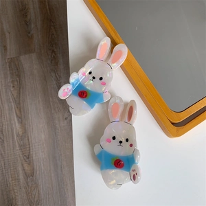 Detailed macro view of pearlescent cartoon rabbit hair claw clips with strawberry pattern