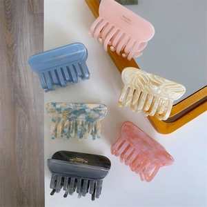 Detailed view of six acetic acid hair claws in various marble and floral patterns