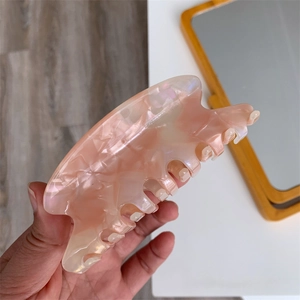 Close-up of pink marble pattern acetate hair claw clip with translucent shell texture