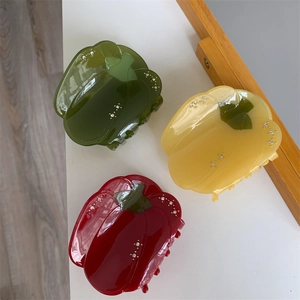Détail de pinces à cheveux en forme de poivron rouge, jaune et vert avec strass brillants