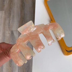 Close-up of pink marble pattern acetate hair claw clip with smooth polished finish