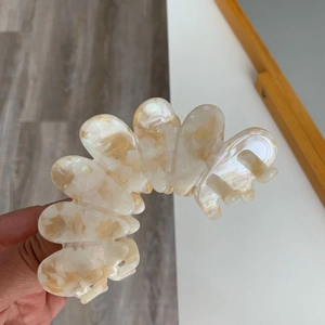Detail of high-quality acetate hair claw clip with cream marble texture and pearl finish