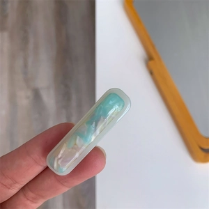 Close-up of blue marble pattern acetate hair clip featuring a rectangular minimalist design