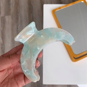Detailed shot of light green marble texture on a crescent acetate hair claw clip