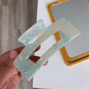 Detail of large rectangle hair claw clip with green and cream marble acetate pattern