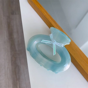 Gros plan sur une pince à cheveux bleu clair avec un nœud argenté et cristal brillant