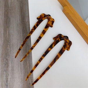 Detail view of tortoiseshell U-shaped hairpins with cute puppy design for long hair styles