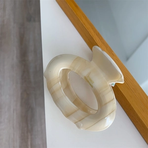 Détail d'une pince à cheveux effet marbre crème avec marquage France Handmade de qualité