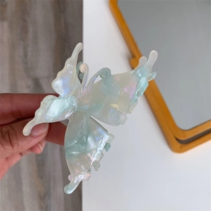 Detail of translucent butterfly claw clip with iridescent pearl finish and cutout wings