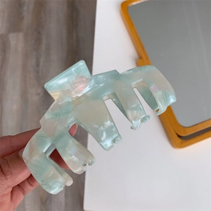 Close-up of marble mint green acetate hair claw clip with pearlescent finish