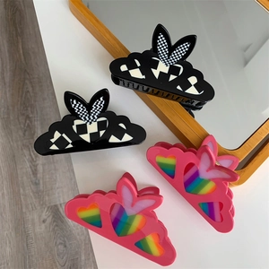 Checkered pattern and rainbow heart hair clips with rabbit ear design on white background