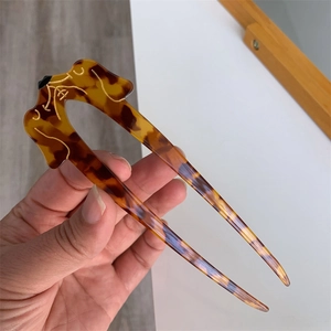U-shaped tortoise shell hair pin featuring dog design with gold accents for long hair styles