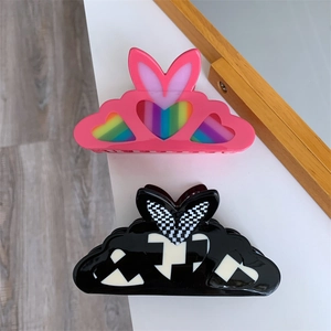 Detail view of two acetate hair claws with rabbit ears, heart patterns and checkered design