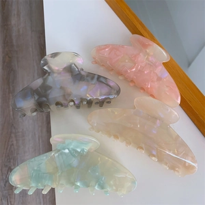 Starfish acetate shark hair clips in four pastel colors on a white surface for women
