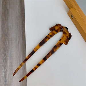 Detail of tortoise shell dachshund dog design on creative U-shaped hair stick for women