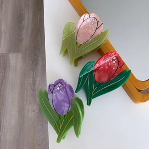 Vue détaillée des pinces à cheveux tulipe en rose, rouge et violet avec strass brillants