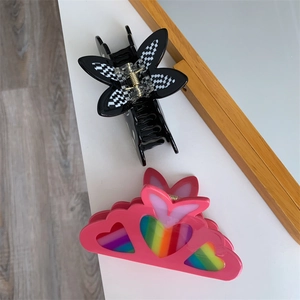 Close-up of checkered butterfly hair claw and rainbow heart resin hair clips for women