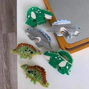 Detail of assorted cartoon dinosaur hair claws made of marble textured acetate fiber