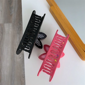 Detail of checkerboard bow and pink floral pattern on acetate claw hair clips