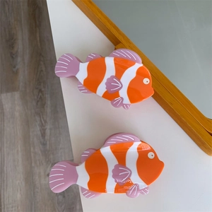 Dettaglio di mollette per capelli a forma di pesce pagliaccio in acetato con pinne viola