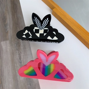 Detail view of heart-shaped hair claws with checkerboard and rainbow patterns