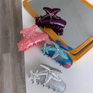 Detailed top view of starfish hair claws with sparkling rhinestones in four diverse colors
