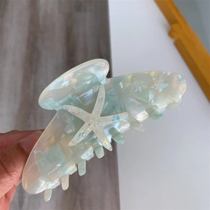 Macro detail of the iridescent starfish claw clip with shimmering glitter and acetate finish
