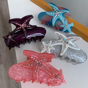 Detailed view of four acetate starfish hair claws with sparkling rhinestones in various colors