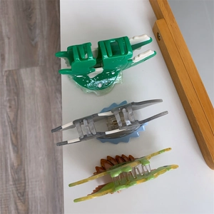 Detailed view of colorful acetate dinosaur hair claws with secure metal spring mechanism