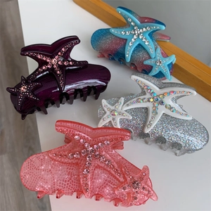 Detail view of starfish claw clips in purple snake skin, pink grid, and glitter finishes