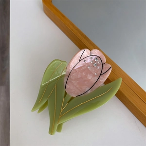 Détail d'une pince à cheveux tulipe en acétate marbré rose et strass scintillants