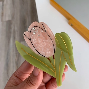 Détail d'une pince à cheveux tulipe avec pétales en acétate rose et strass brillants