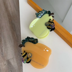 Creative pear-shaped acetate hair claws with bee accents in amber and green colors