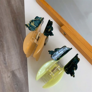 Chic butterfly acetate hair claws in amber and green marble finish for elegant styling