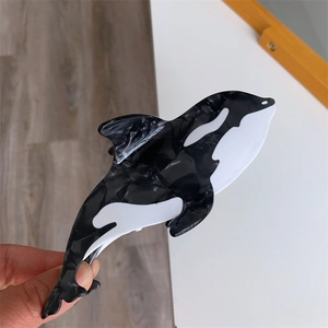 Detail of orca shaped hair claw clip in premium black and white marbled acetate finish