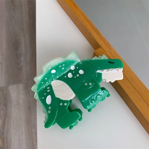 Detailed close-up of a green acetate dinosaur hair claw clip with rhinestones