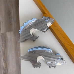 Detail of small dinosaur hair claw clips with marble texture and light blue fins