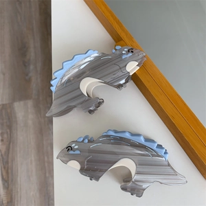 Close-up of small dinosaur acetate hair claws with grey marble pattern and blue details