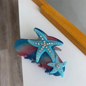 Sparkly ocean-style starfish hair claw clip with blue and red gradient acetate finish