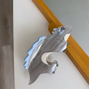 Detail of gray dinosaur hair claw clip with blue fins made of premium acetate