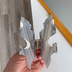 Detail showing acetate butterfly hair claw with grey marble texture and spring mechanism