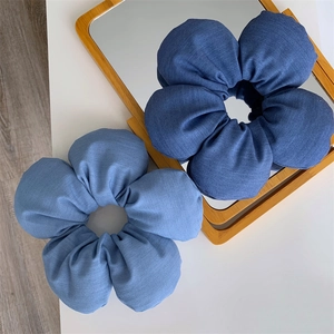 Macro shot of large denim flower hair ties in dark and light blue on a vanity