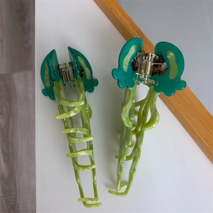 Detail of green acetate jellyfish hair claws with marble texture and metal spring