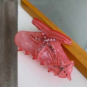Close-up of pink starfish claw clip with sparkling rhinestones and mesh texture