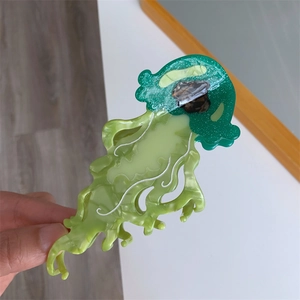 Detail of glitter green jellyfish hair claw clip made of acetate with shimmering texture