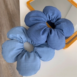 Detail of blue denim fabric sponge flower scrunchie with clear textile texture and 3D design