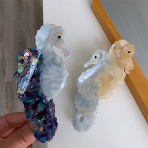 Detail view of acetate seahorse hair claws with floral and pearlescent textures