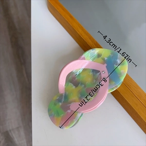 Detail of creative flip-flop hair claw clip with colorful ink texture and crystal accents